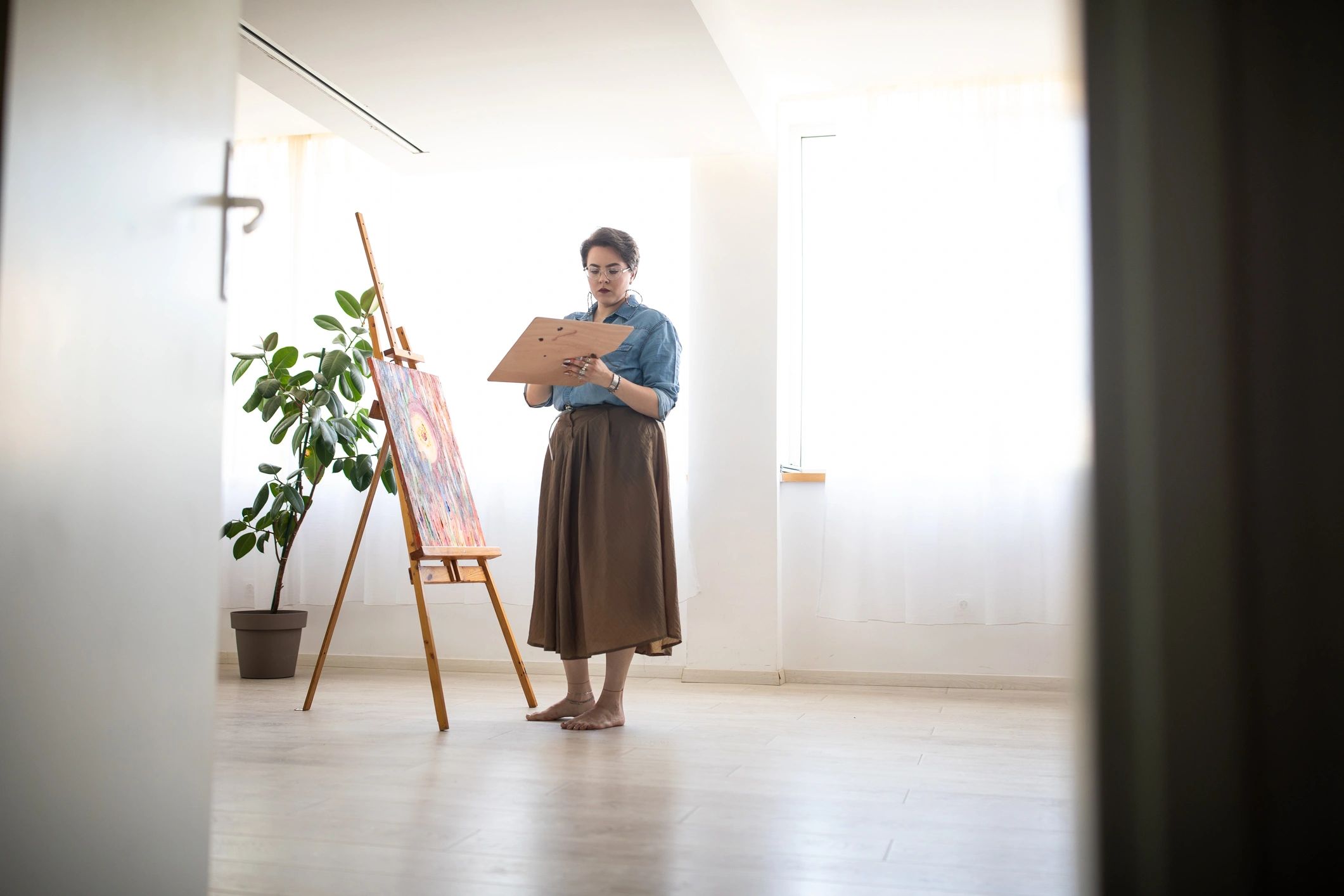 Creative woman painting on canvas at art studio