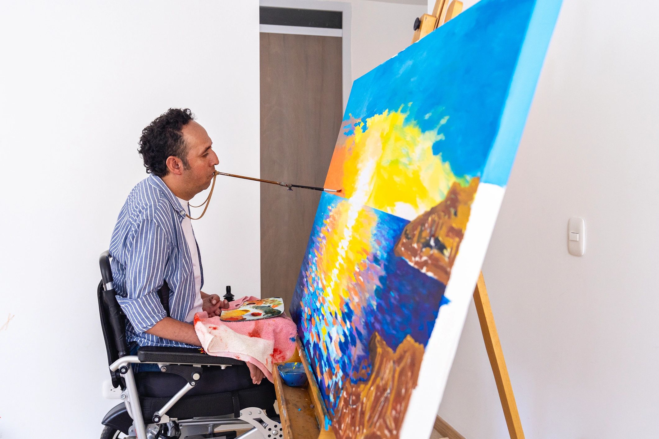 Artist painting a sunset seascape in a home studio